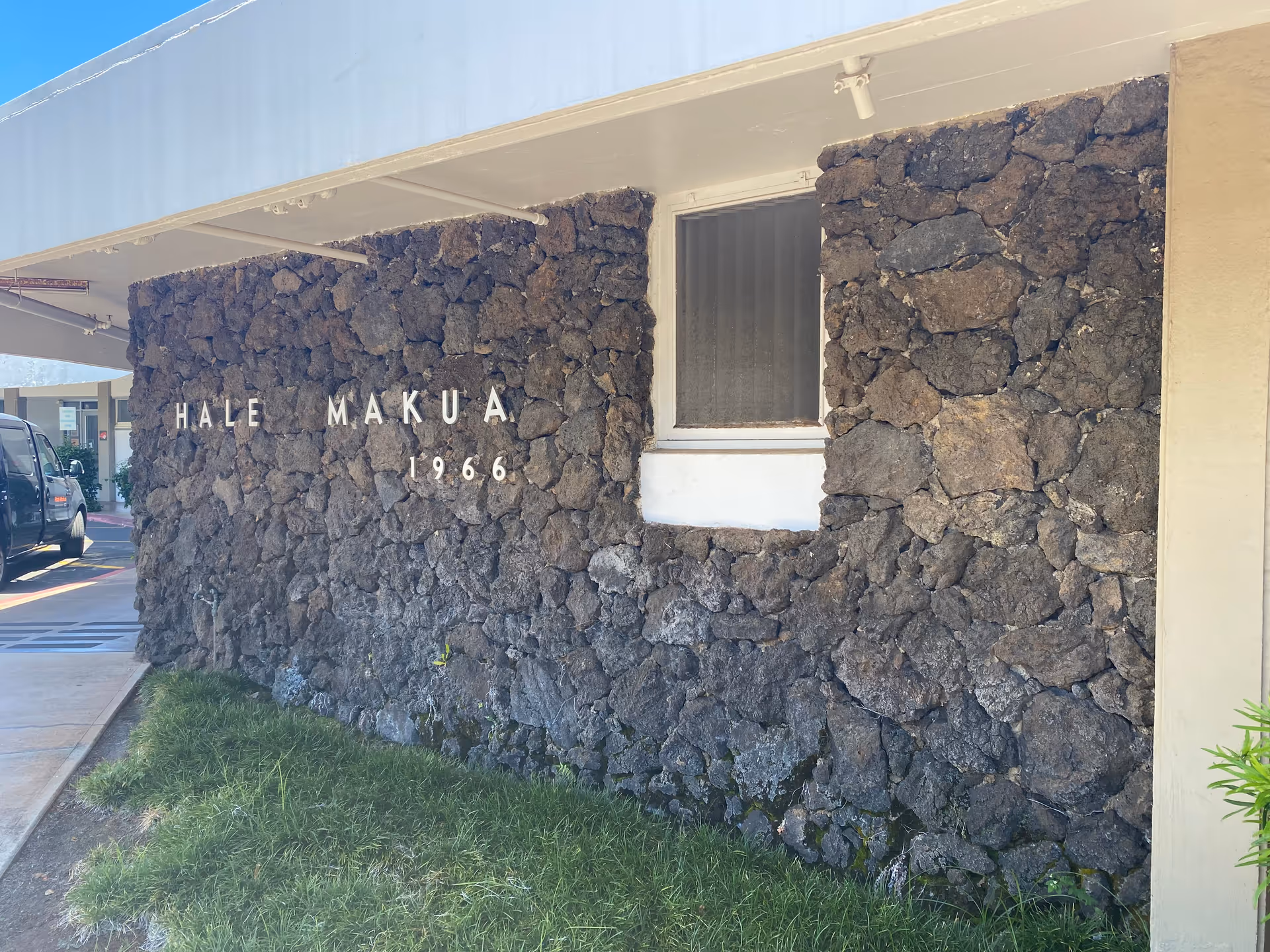 Stone-walled building exterior with a sign reading Hale Makua 1966.