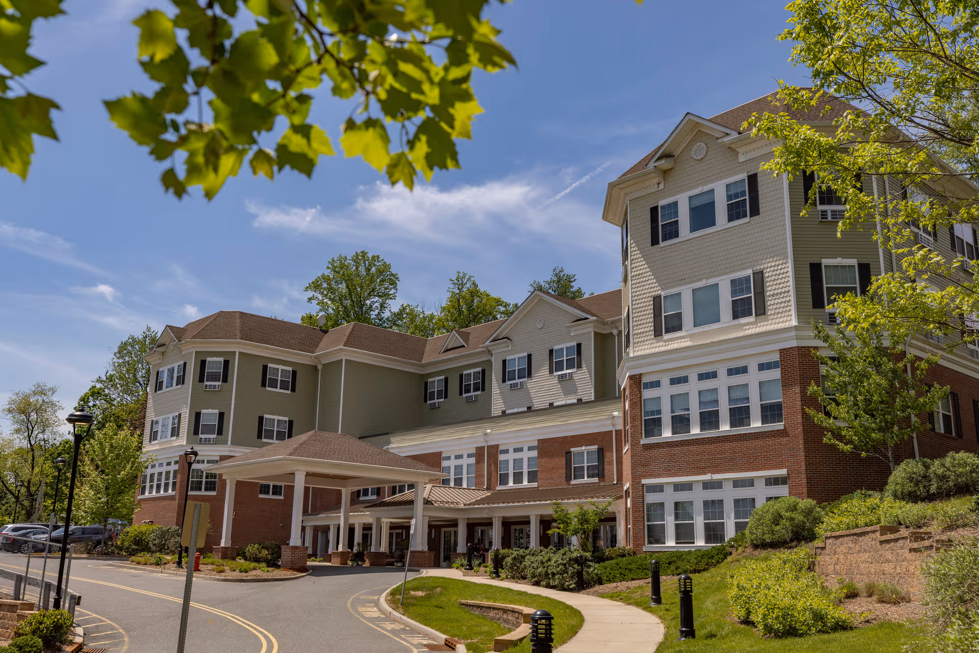 Exterior view of Mira Vie at Clifton senior living facility with brick facade and entrance canopy.