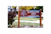 Outdoor sign on a lawn with trees advertising a rehabilitation and nursing facility.