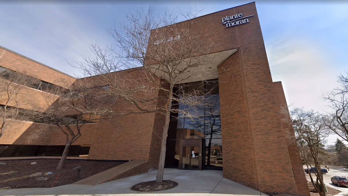 Exterior view of a brick HarmonyCares Medical Group building with glass entrance