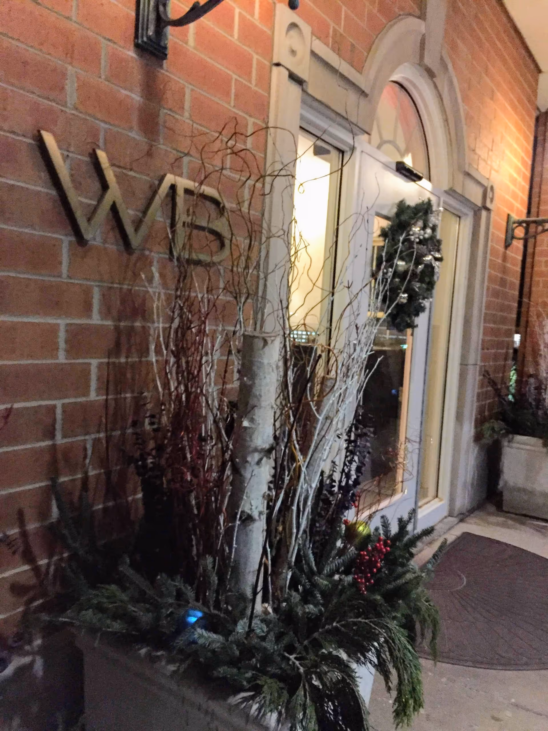Warren Barr North Shore entrance with wreath, glass door, and decorative planters.
