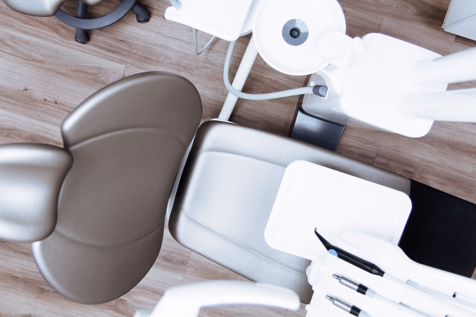 Overhead view of a dental chair with instruments in a clinical treatment room.