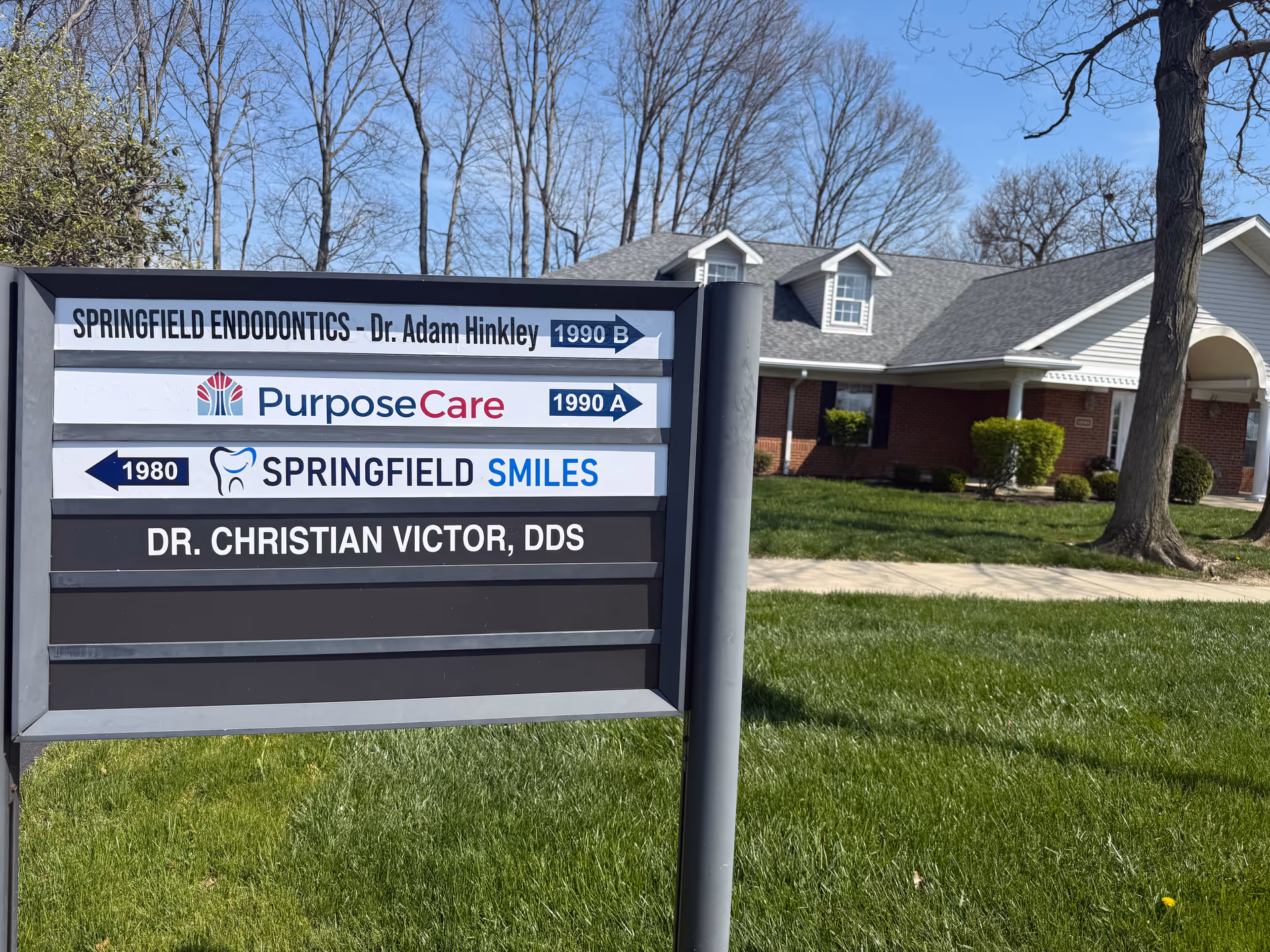 Outdoor view of a facility sign in front of a brick senior care building.