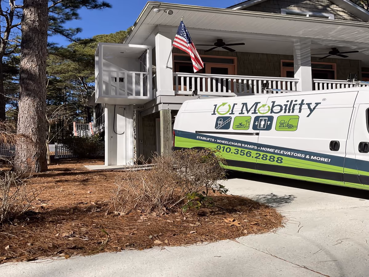 Two-story building with a mobility van parked in front and an American flag.