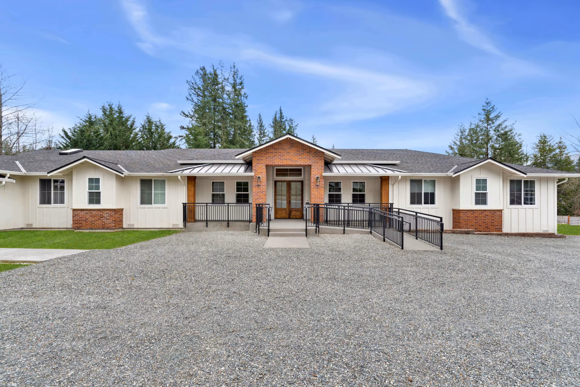 Front exterior of a single-story North Bend Senior Living building with brick entry and ramps.
