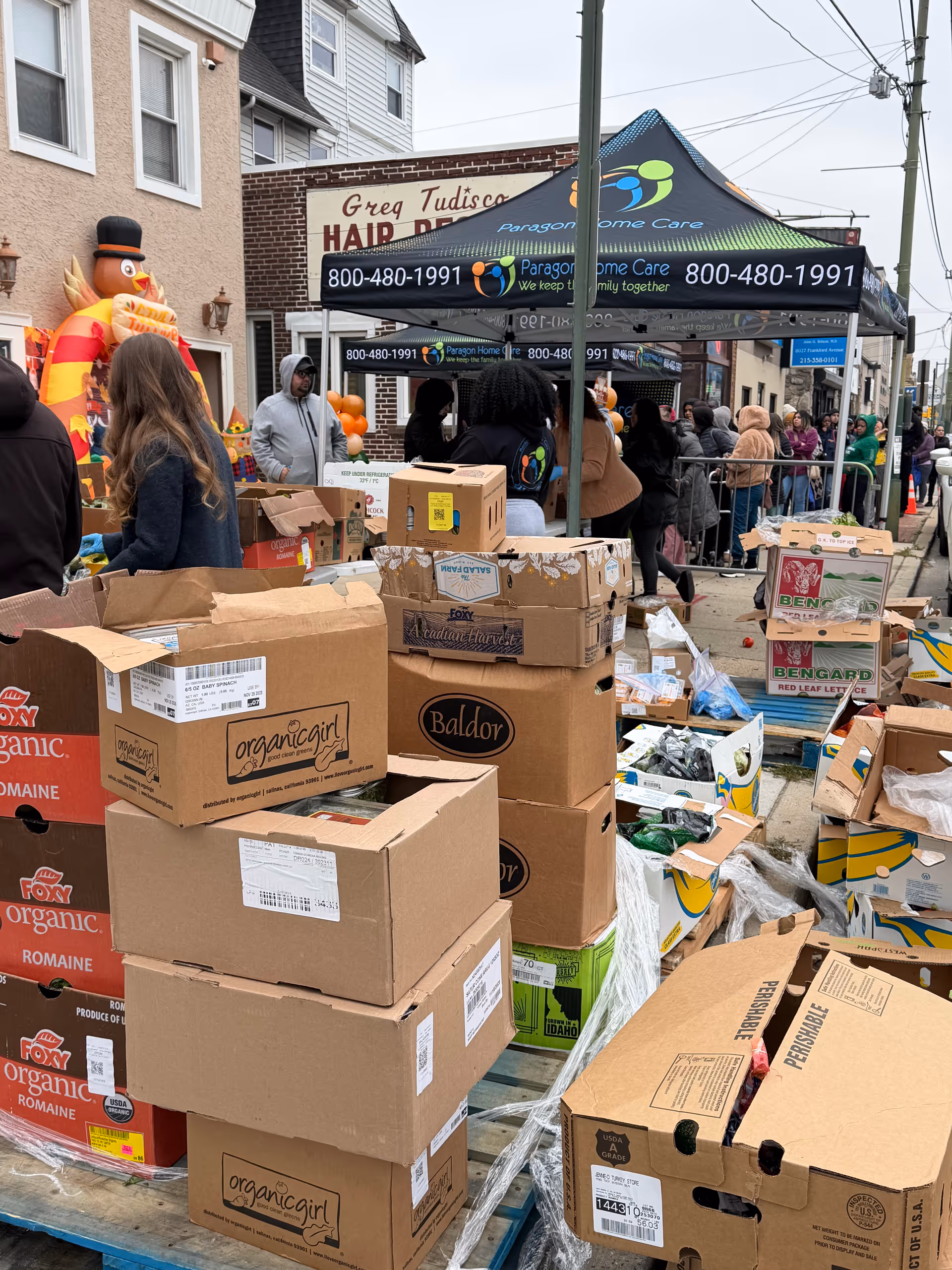 Outdoor charity event with Paragon Home Care tents and donation boxes.