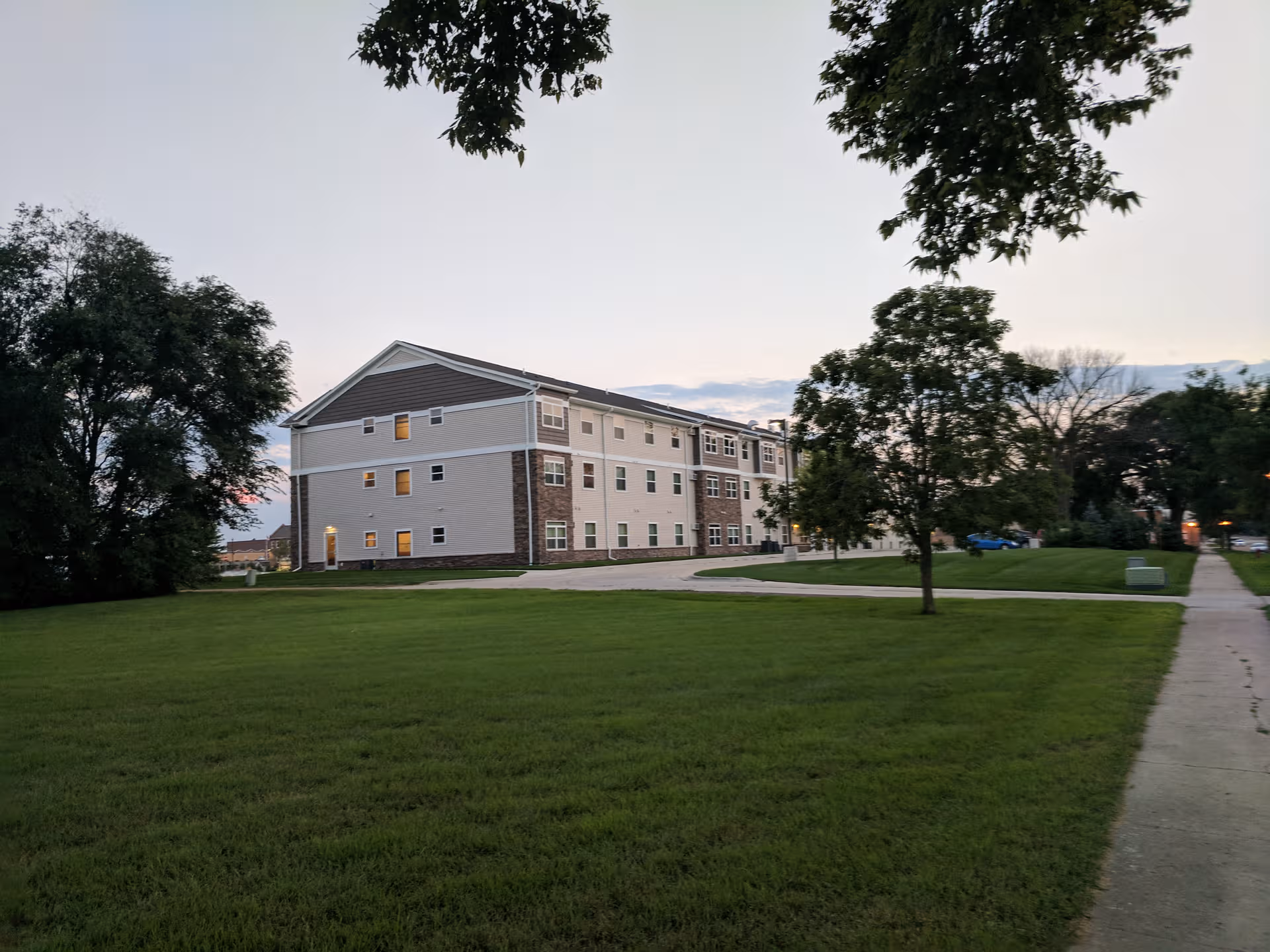 Heritage Pointe Senior Living building exterior with manicured lawn and trees.