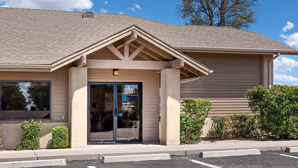 Exterior of Banner Home Care Payson facility with covered entrance, glass doors, and shrub landscaping.