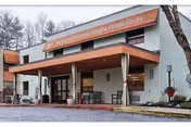 Exterior view of Westgate Hills Rehabilitation and Nursing Center entrance with awning and benches.