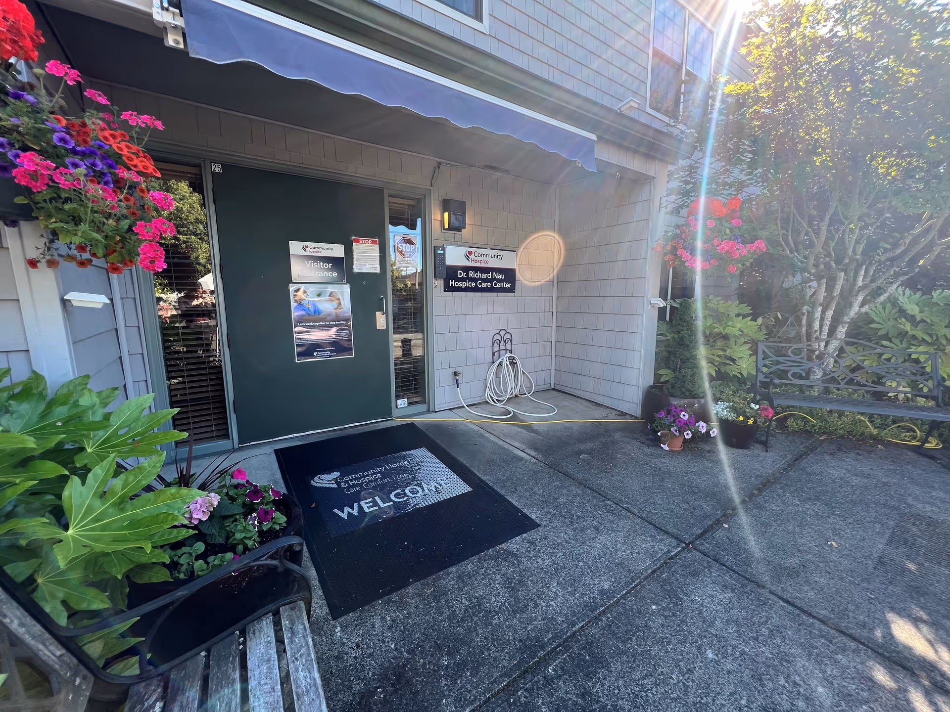 Exterior entrance to Community Home Health and Hospice in Longview, with plants and a welcome mat.