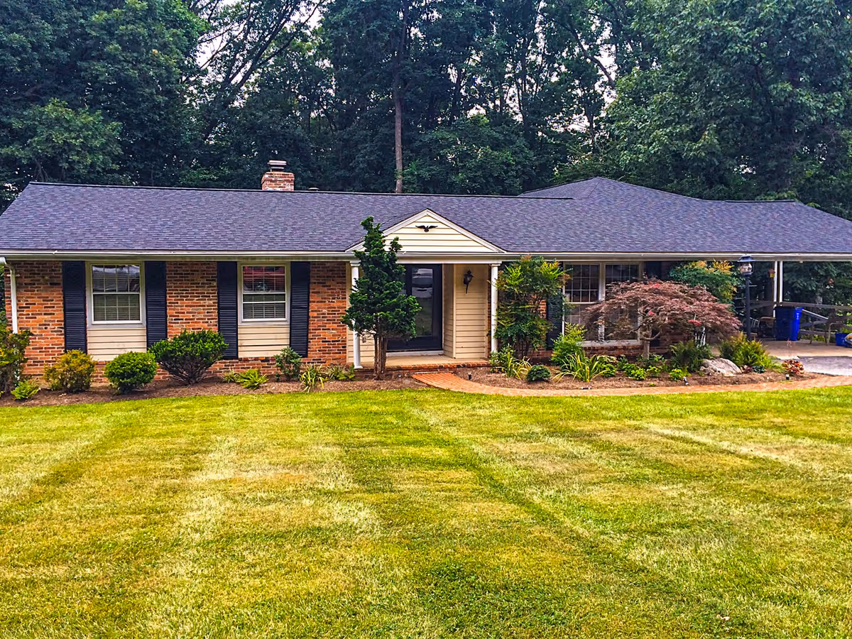 Single-story brick building with a manicured lawn, shrubs, and a front entry.