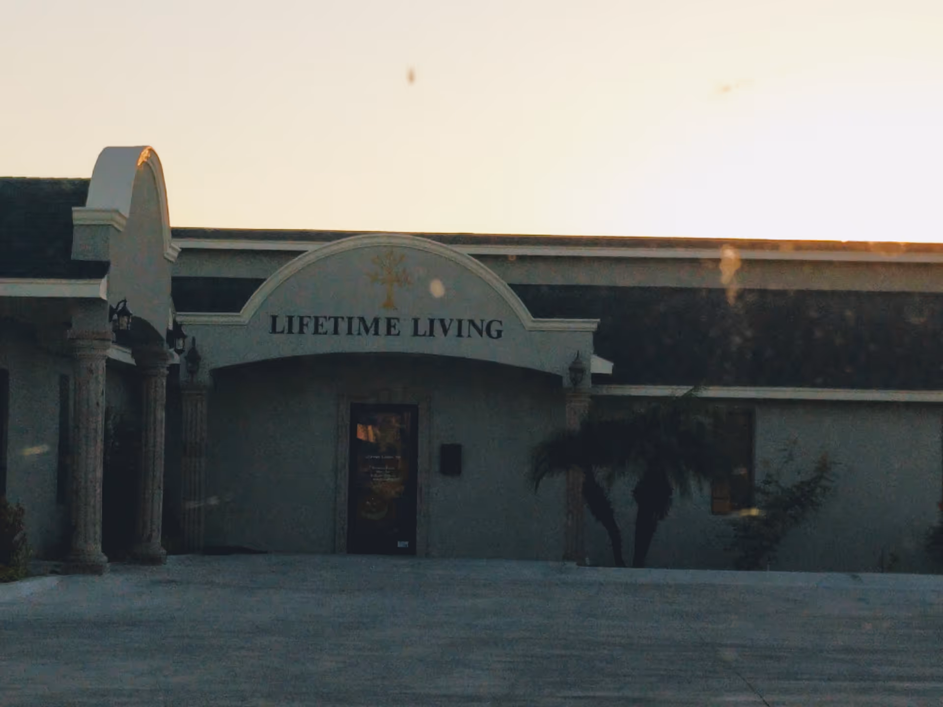 Front exterior of Lifetime Living facility with arched entrance and sign.