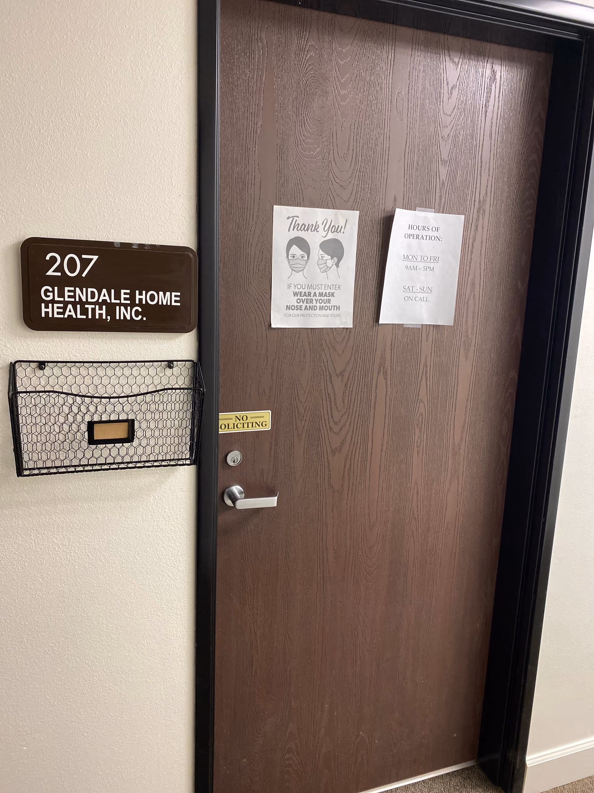 Door labeled 207 Glendale Home Health, Inc. with notices and a mail slot nearby.