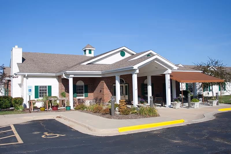 Single-story Oakley Courts assisted living facility with brick facade, covered entrance, and wheelchair-accessible signage.