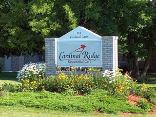Cardinal Ridge Residential Care front sign with flower beds and trees.