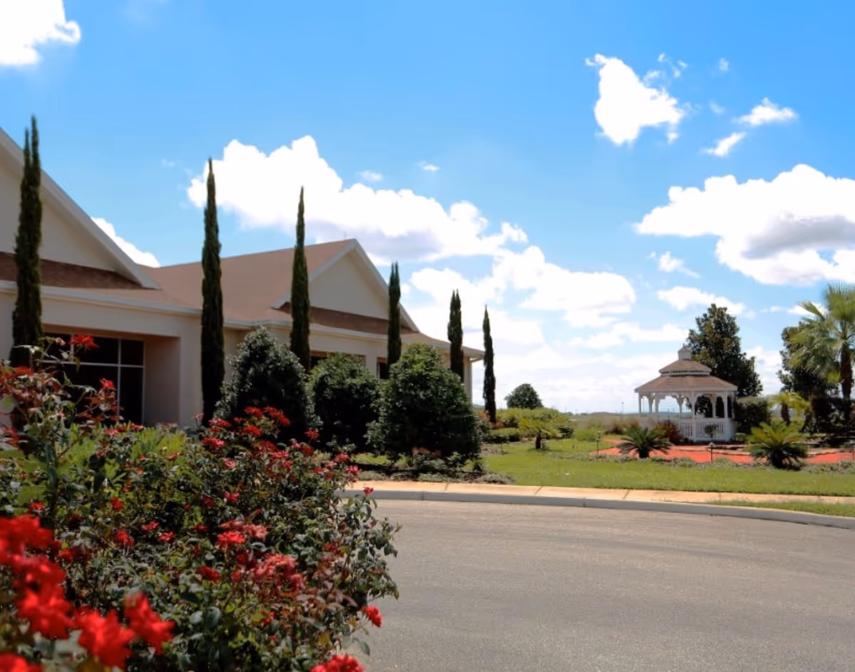 Sunny exterior of a hospice campus with a gazebo and landscaped gardens.
