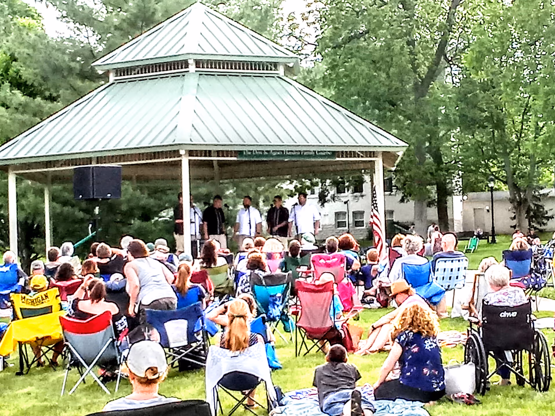 Outdoor pavilion at Grand Traverse Pavilions featuring a band performing to a seated audience.