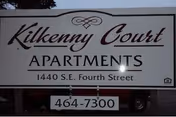 Sign reads Kilkenny Court Apartments; address 1440 SE Fourth Street; phone 464-7300.