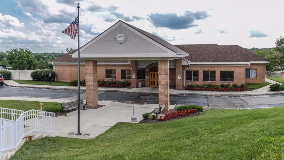 Legacy Centerville exterior brick building with a covered entrance and flagpole.