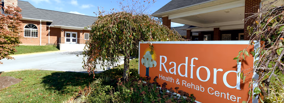 Exterior view of Radford Health and Rehab Center with orange sign and brick facade.