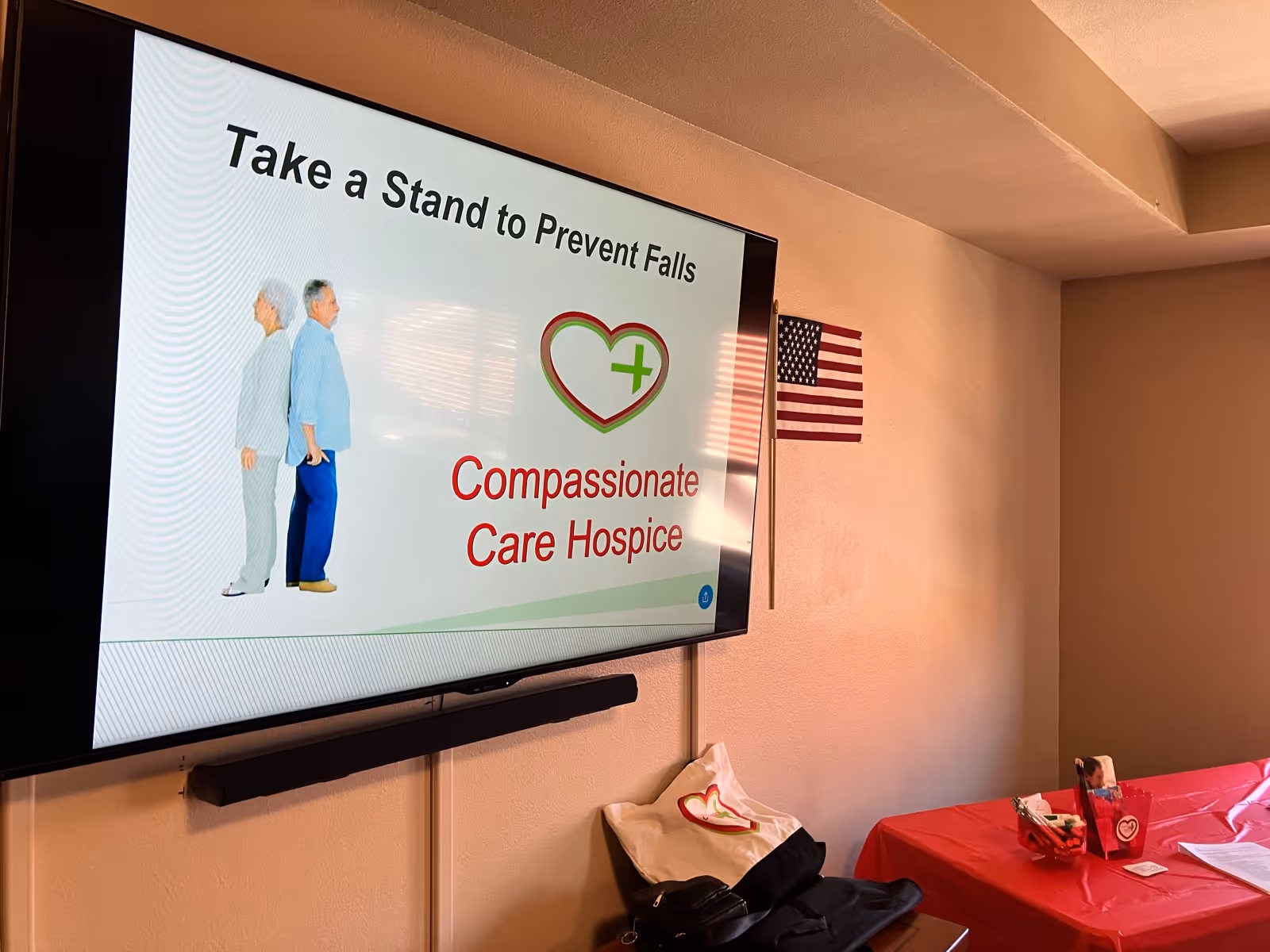 A conference room with a large screen presentation about Compassionate Care Hospice.