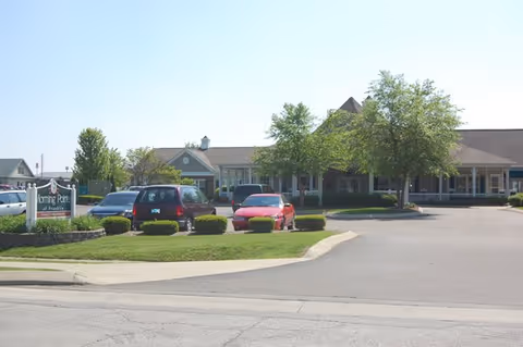 Exterior view of Morning Pointe of Franklin with parked cars and a sign.