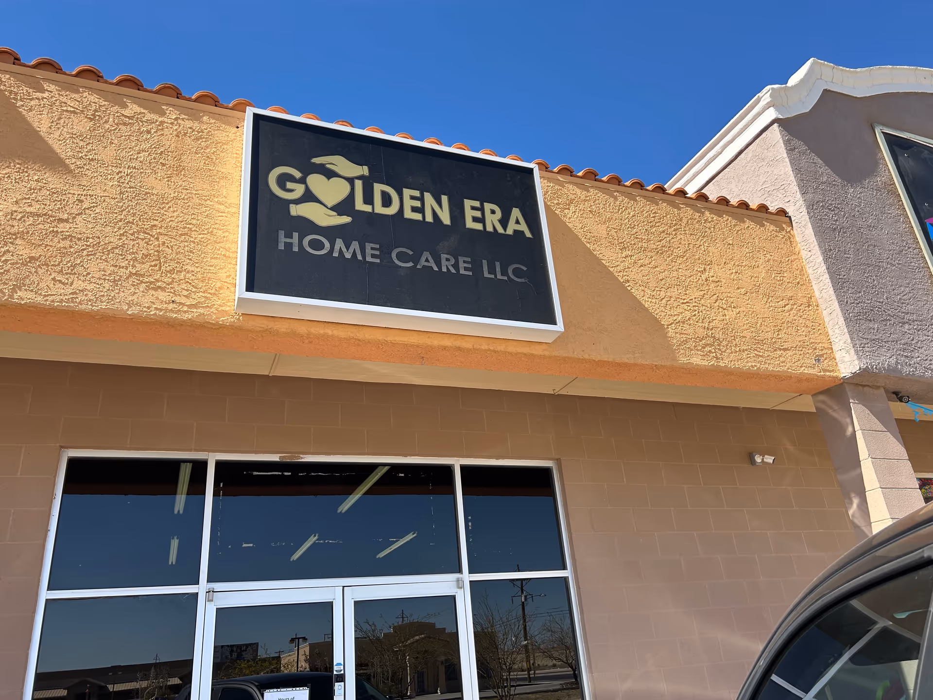 Exterior view of Golden Era Home Care LLC building with sign and glass doors.
