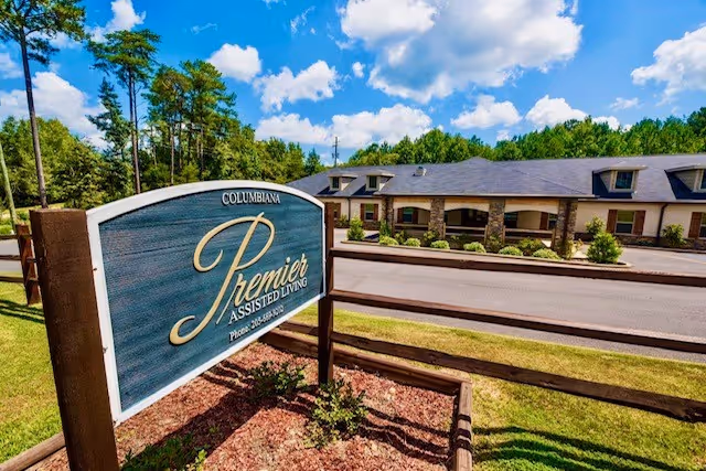 Exterior view of Premier Assisted Living facility with a blue sign and building entrance.