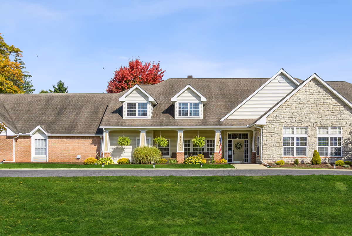 Front view of a single-story senior living facility with manicured lawn and welcoming entrance.
