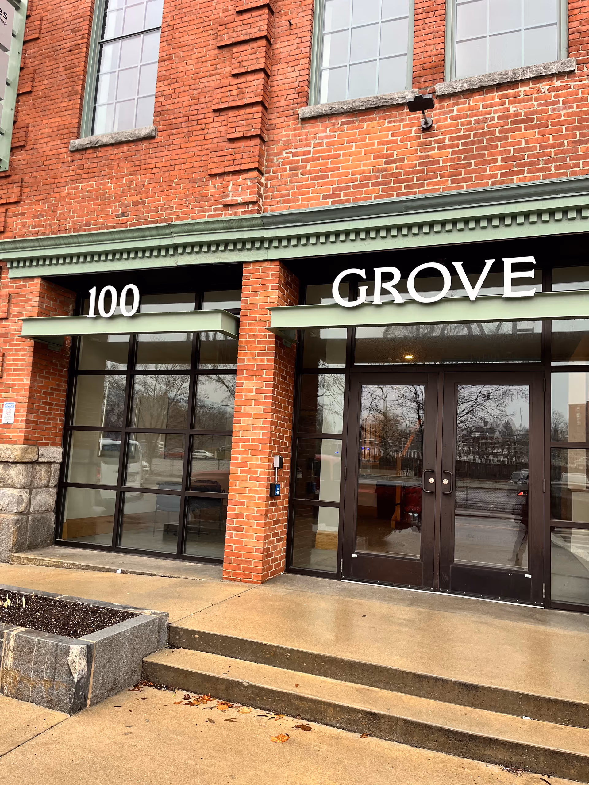 Brick building exterior with glass entrance and GROVE sign.