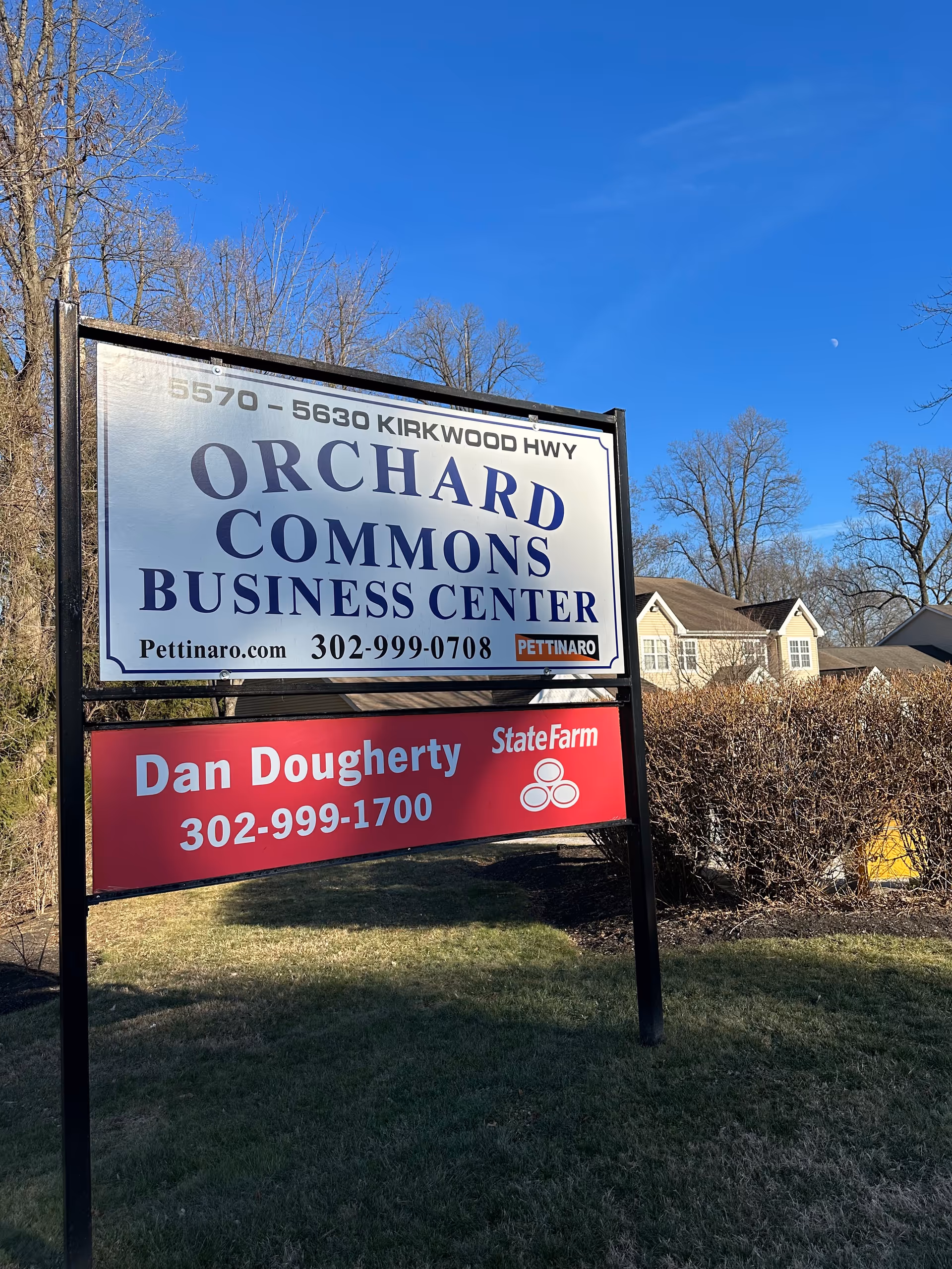 Outdoor sign advertising Orchard Commons and Dan Dougherty at a business center entrance.