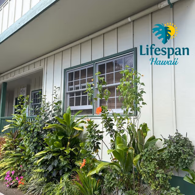 Exterior view of Lifespan Hawaii building with lush tropical plants along the facade.