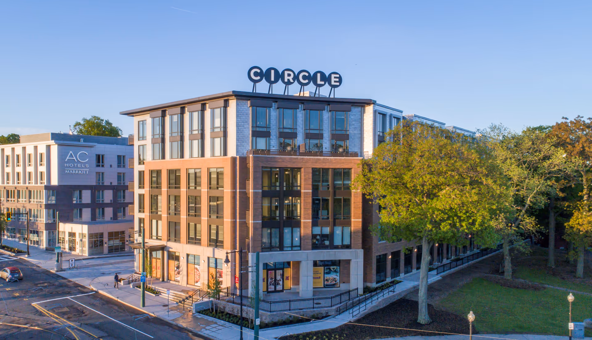 Exterior view of a multi-story brick building with a Circle sign on the rooftop.