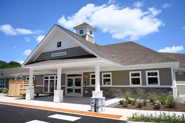 Front view of Fallbrook Woods senior living facility with a gabled roof and welcoming entrance.