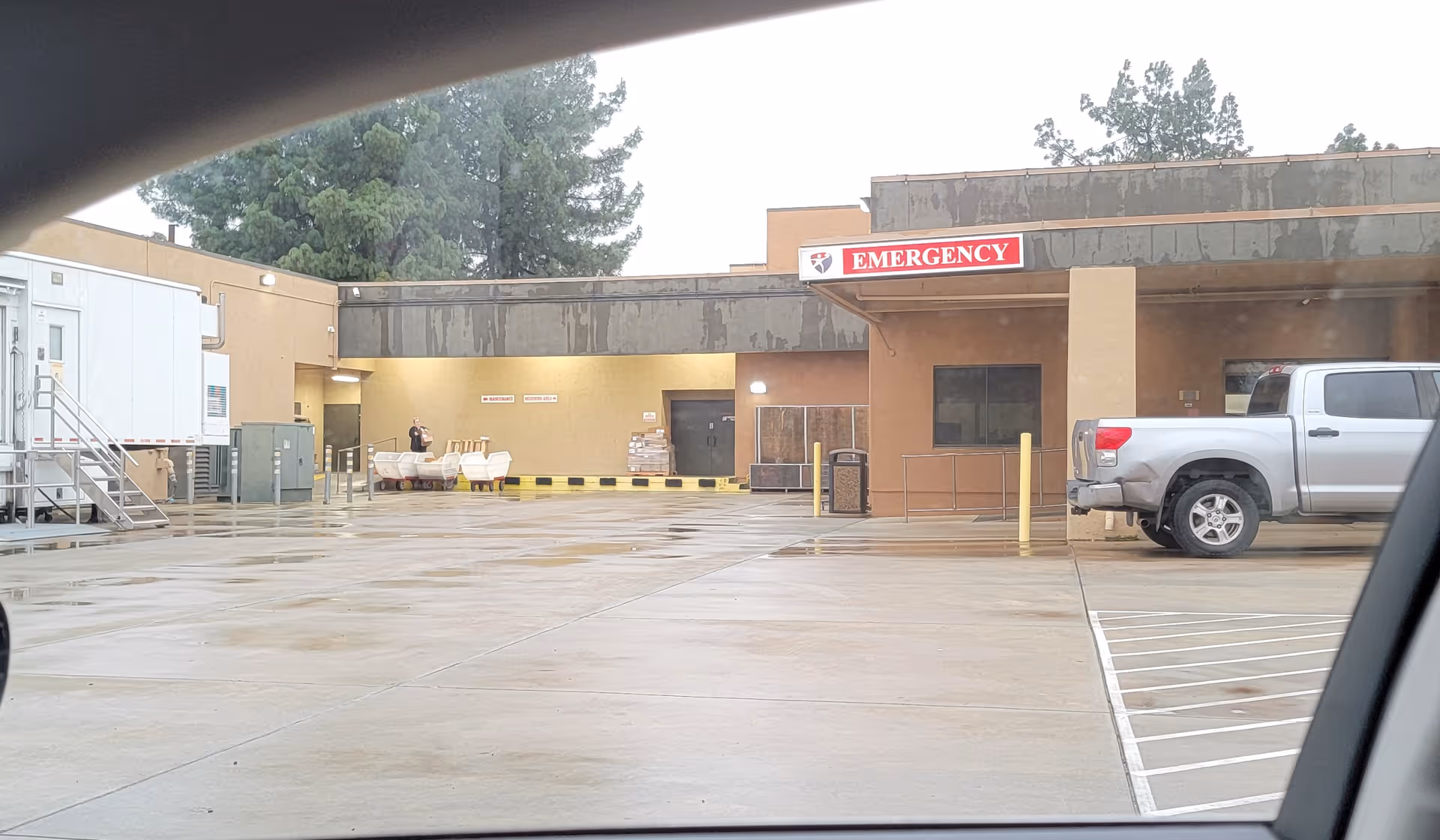 Exterior view of Colusa Medical Center emergency entrance with parking lot and truck.