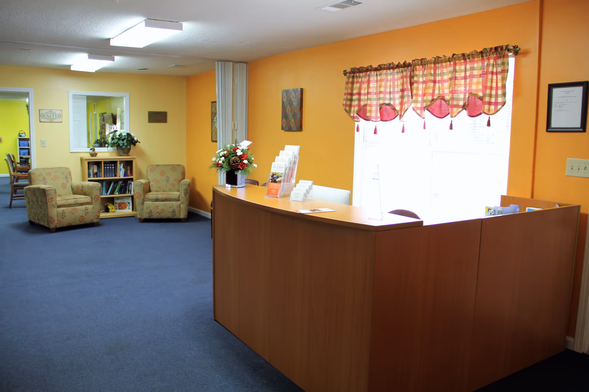 Bright orange lobby area with curved reception desk and lounge chairs.
