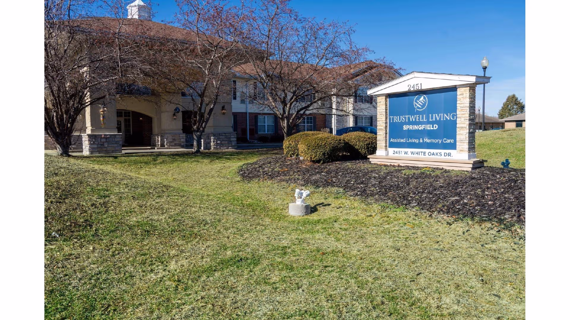 Exterior view of Trustwell Living Springfield with blue sign near entrance.