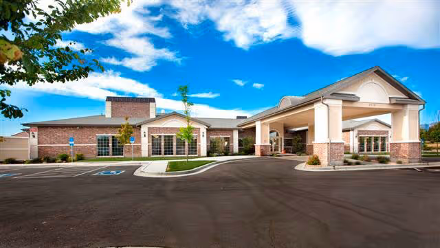 Exterior view of Rocky Mountain Care Riverton facility with covered entrance and parking.
