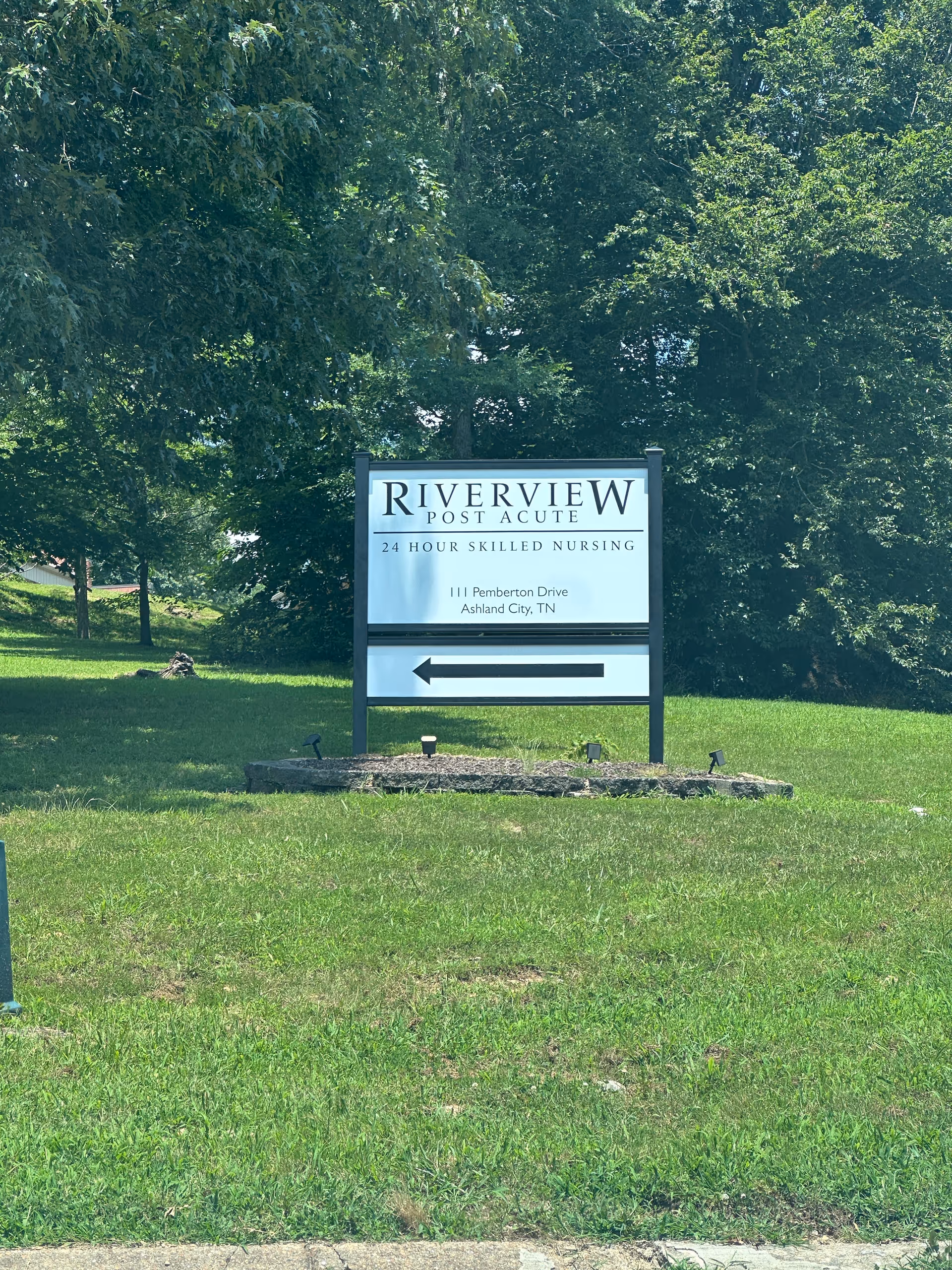 Exterior sign for Riverview Post Acute on a grassy area with trees.