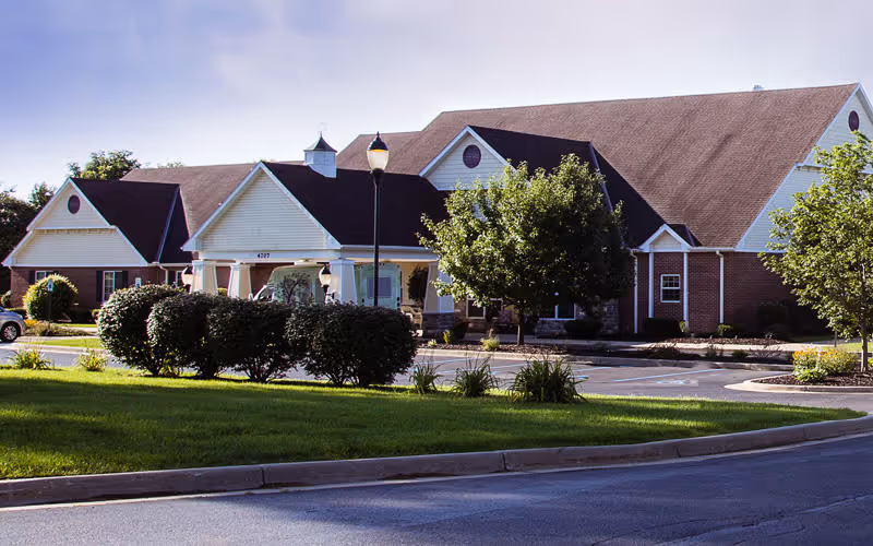 Exterior view of Bickford of Portage with a brick building, manicured lawn, and driveway.