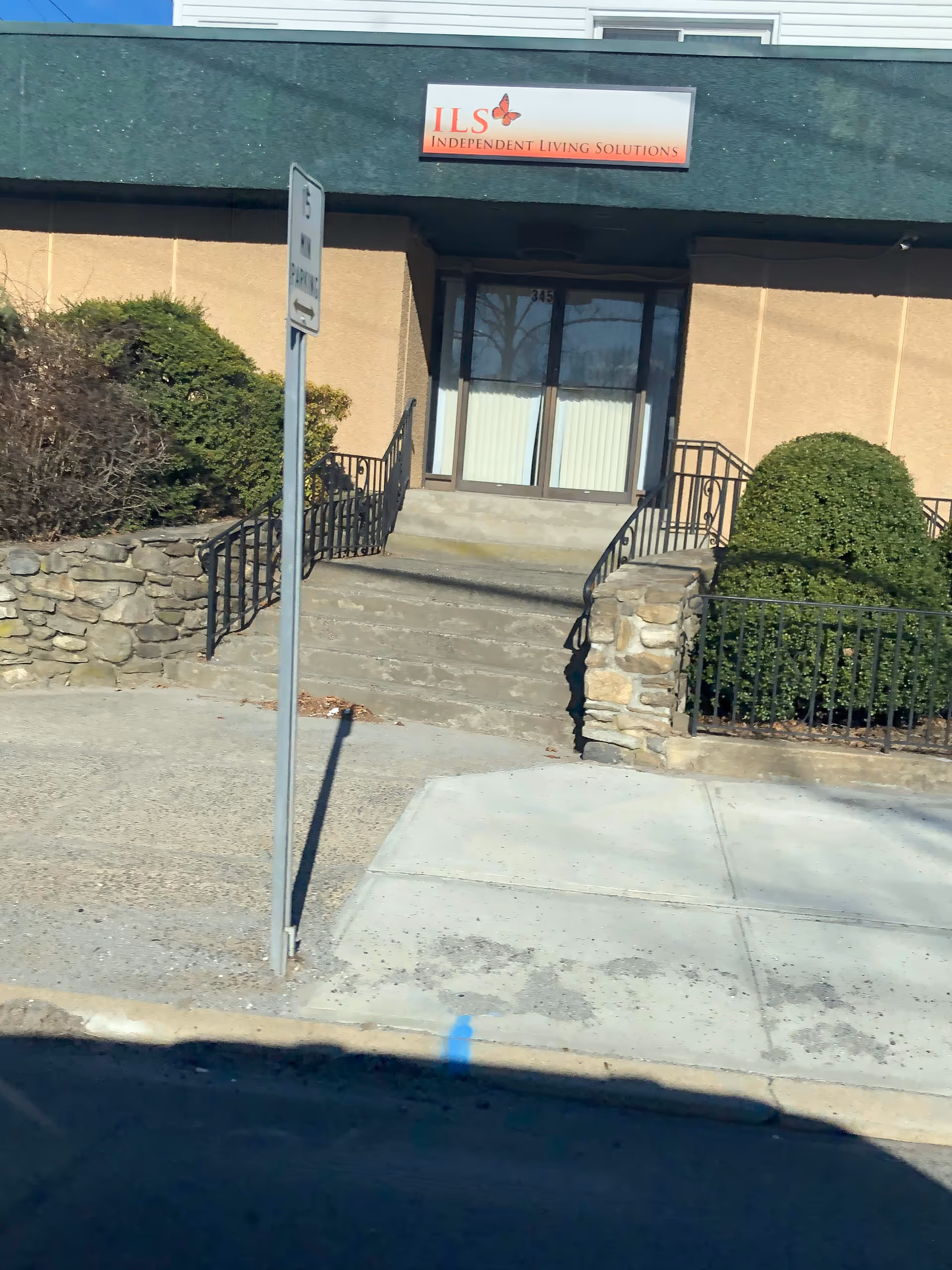 Exterior entrance to Independent Living Solutions facility with stairs and shrubbery
