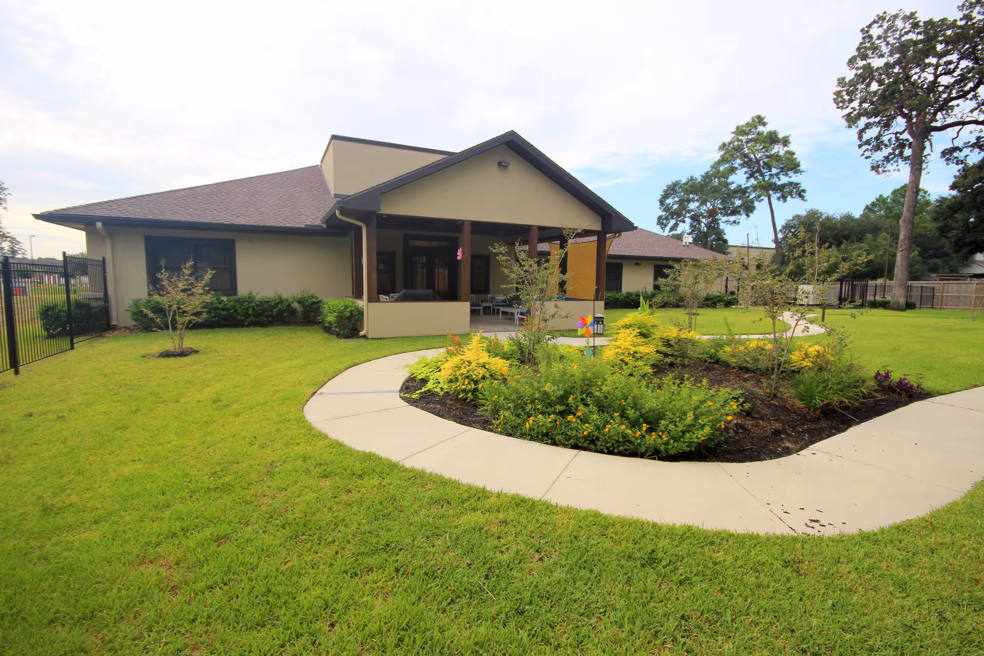 Single-story senior living facility with a curved walkway and landscaped front lawn.