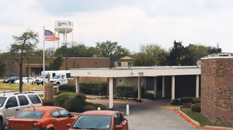 Exterior view of a Lancaster Long Term Care Partners facility entrance with a covered drop-off.