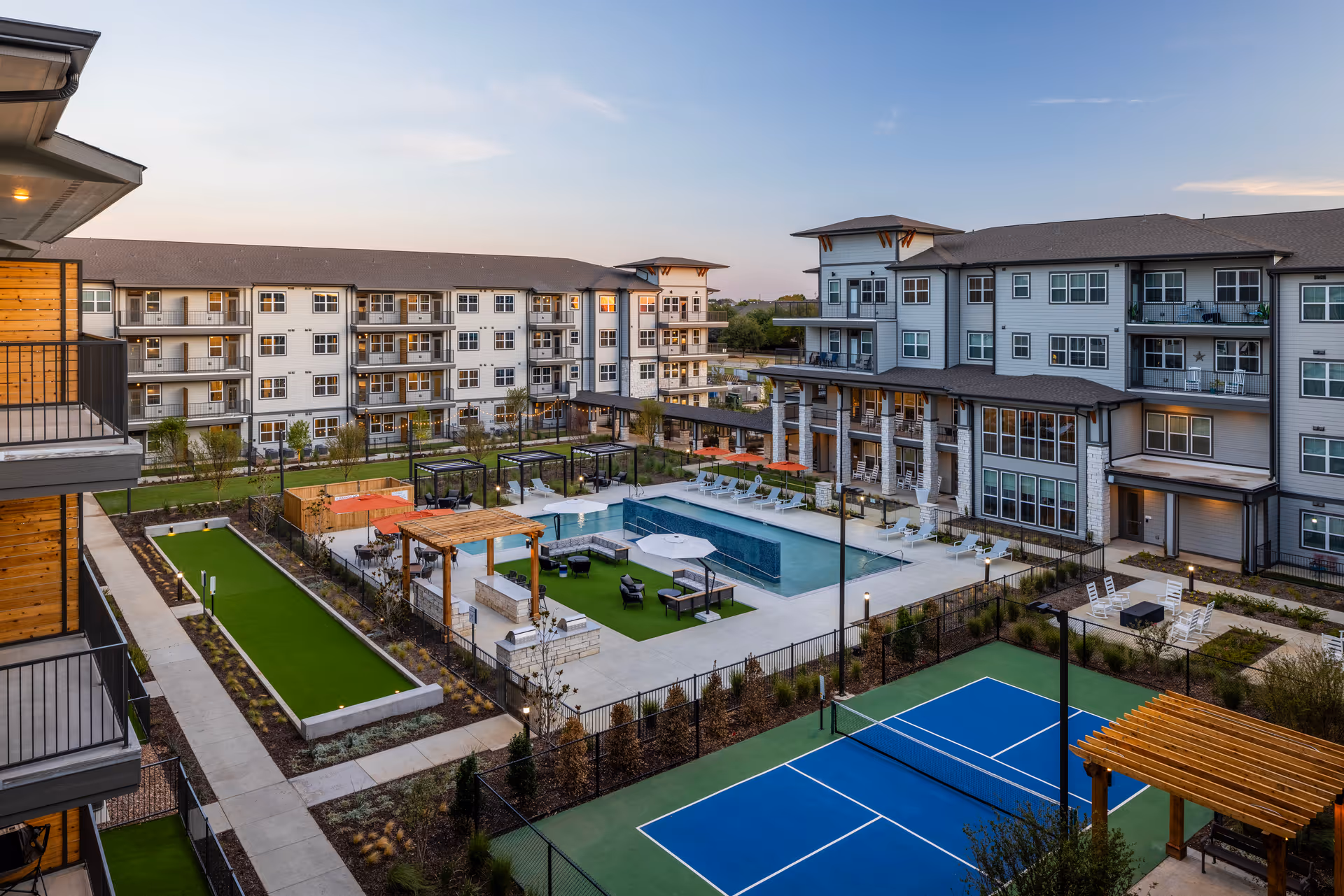 A senior living community outdoor courtyard featuring a swimming pool, seating areas, and adjacent buildings.