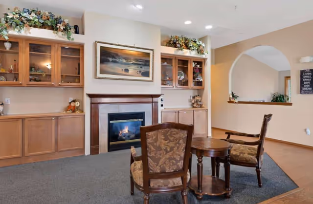 Cozy living area with a fireplace, built-in cabinets, and seating around a small table.