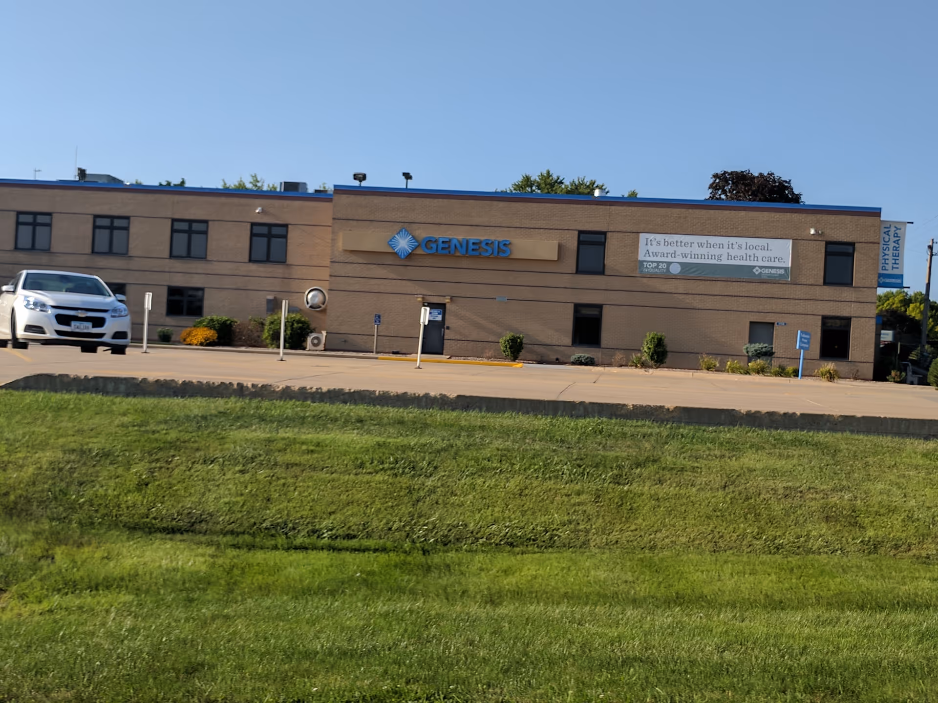 Front exterior of Genesis Health System DeWitt building with parking lot in foreground