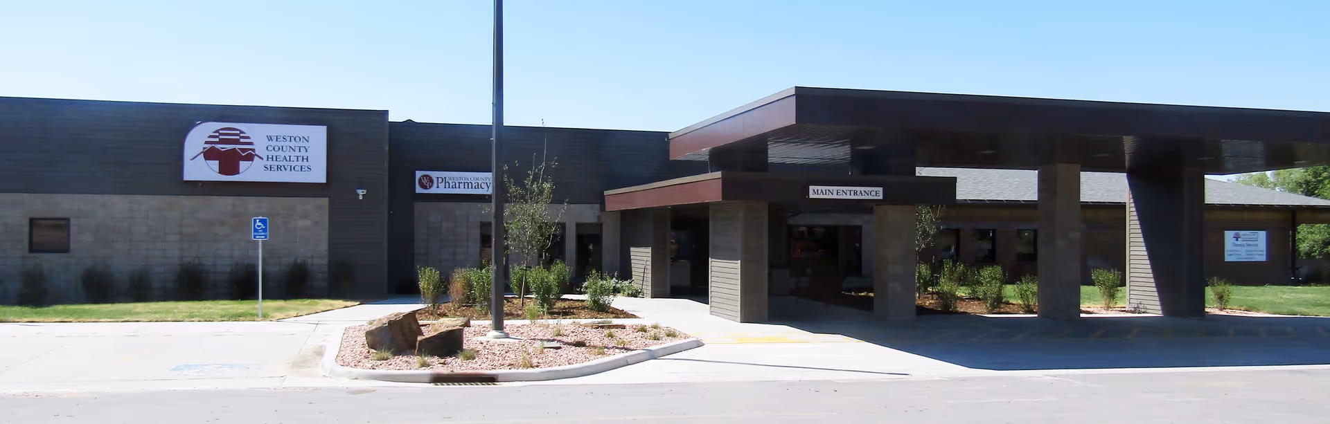 Exterior view of Weston County Health Services building with a main entrance and landscaping.
