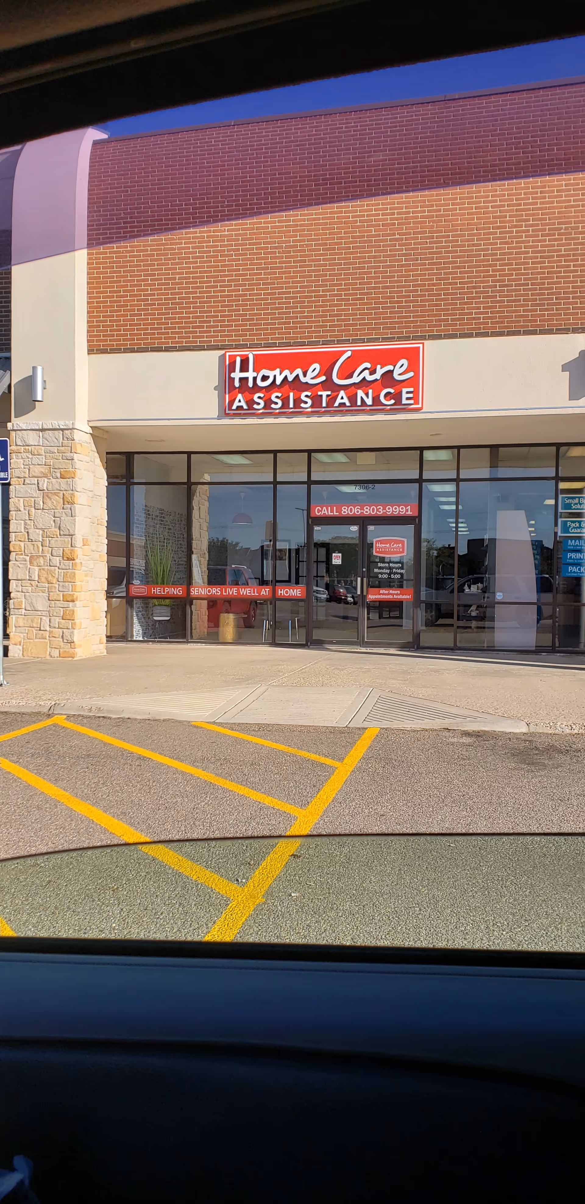 Exterior view of a Home Care Assistance storefront with glass doors and signage.