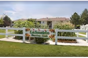 Front exterior view of Lakeside Village Apartments with a white fence and sign.