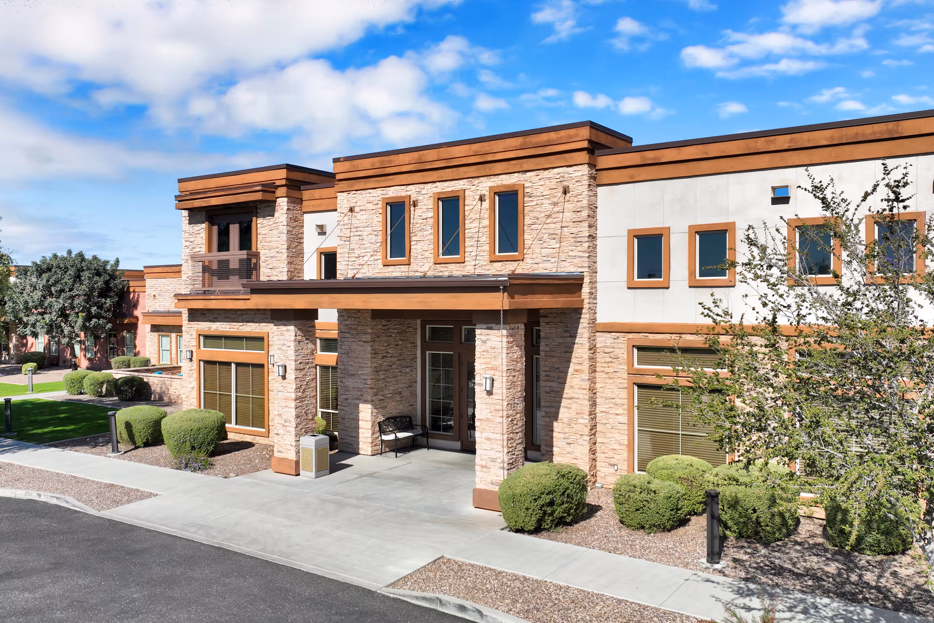 Modern brick exterior of Sky Vista senior living facility with landscaped entrance.